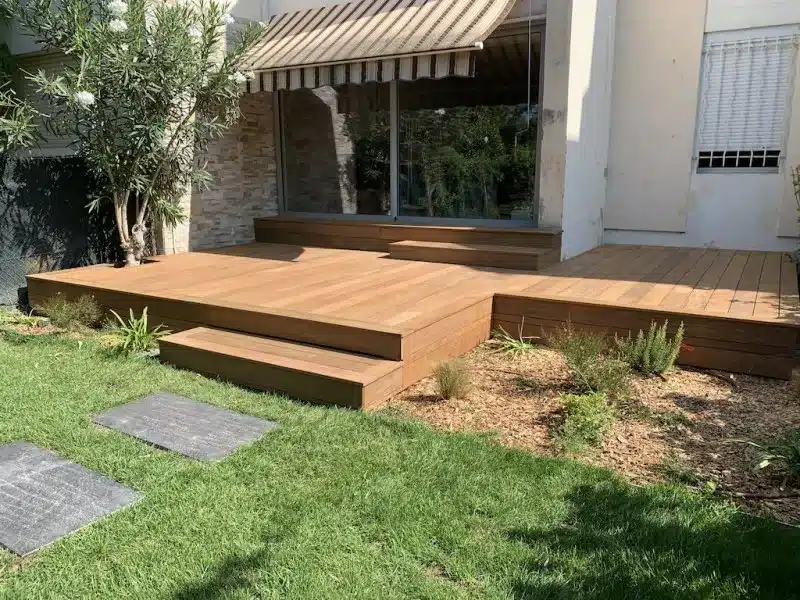 Terrasse Bois Composite et Jardin Moderne Terrasse en bois composite moderne à plusieurs niveaux avec marches menant à une pelouse verte et des pierres de pas.